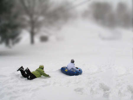 Here's two children enjoying a nice afternoon of sleigh riding.の写真素材