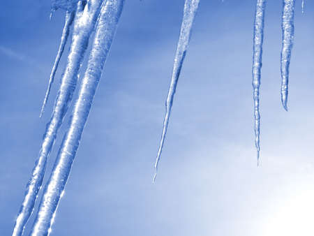 Icicles against a blue sky.の写真素材