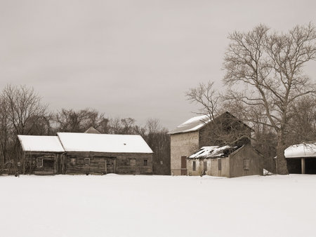 An old fashioned sepia-toned image of an old farm scene in Winter.の写真素材