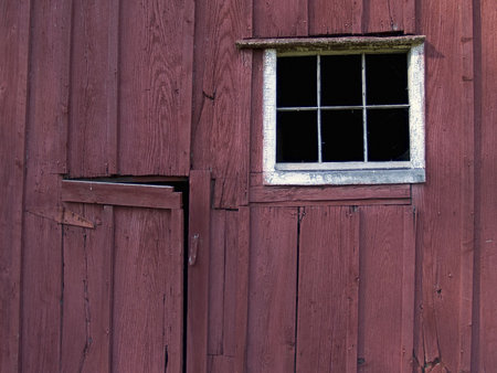 A detailed view of an old wooden barn side and window.