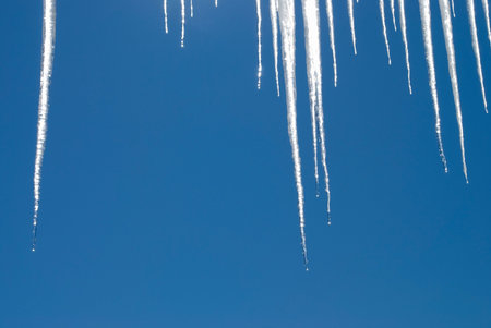 Icicles background photo against a bright blue sky.