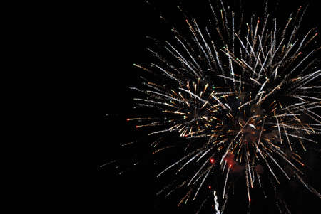 A detailed shot of bright colorful fireworks in the night sky.の写真素材