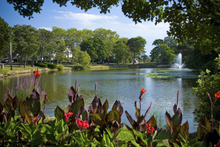 Flowers and overhanging trees frame the view of Spring Lake near the shore in New Jersey.の写真素材