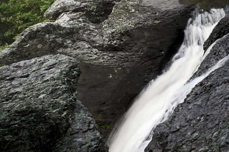 A small stream flows through a rock passageway at the top of Raymondskill Falls in the Pocono Mountains of Pennsylvania.の写真素材