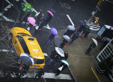 New Yorkers with colorful umbrellas on a messy March morning.