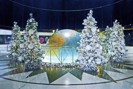 Decorated Christmas trees around a popular globe inside of a Manhattan skyscraper.のeditorial素材