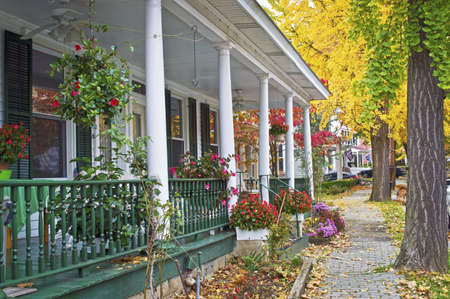 An old fashioned porch and cobblestone sidewalks along this street in Clinton New Jersey のeditorial素材