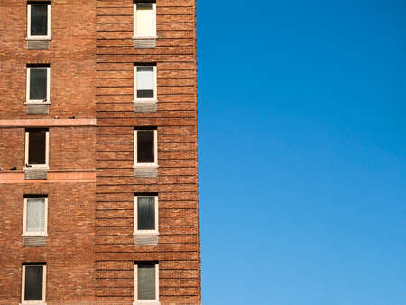 An old brick apartment building against a blue sky in New York City の写真素材