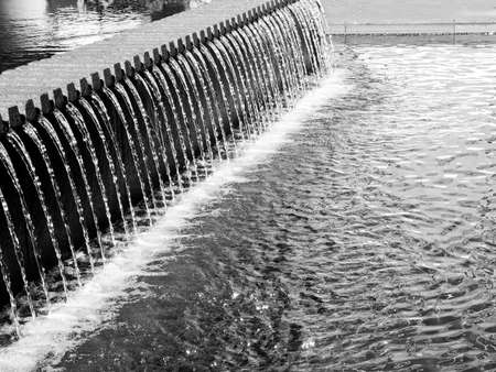 A balck and white look at streams of water in a New York City fountain の写真素材