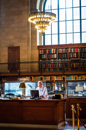 NEW YORK-APRIL 14  A libarian behind the desk at the New York City Public Library on April 14  2014 in Manhattan  The New York City Public Library is the second largest library in the United States のeditorial素材