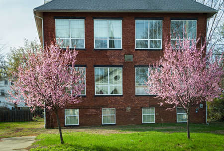 Pink dogwood trees and reflections of a church in this historic 19th century schoolhouse Old Bridge New Jersey のeditorial素材