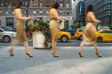 A three part abstract motion blur of a woman walking on a New York City sidewalk のeditorial素材
