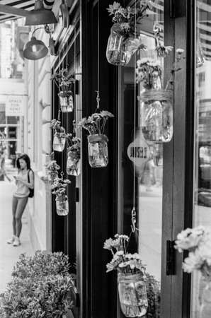 A b w film photograph of a store front on 5th Ave on the lower East Side with hanging plants のeditorial素材
