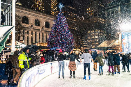 NEW YORK-DECEMBER 10: Ice skaters enjoy the falling snow by the Bryant Park Christmas tree on December 10, 2014 in Manhattan.のeditorial素材