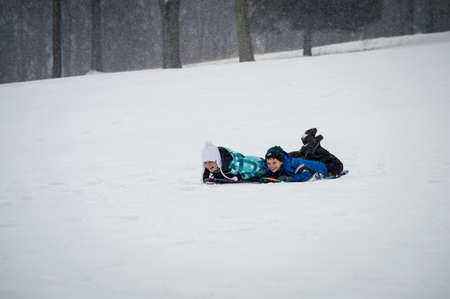 FREEHOLD, NEW JERSEY-FEBRUARY 14- Kids enjoy sledding in Monmouth Battlefield State Park on February 14 2014 in Freehold New Jersey.のeditorial素材