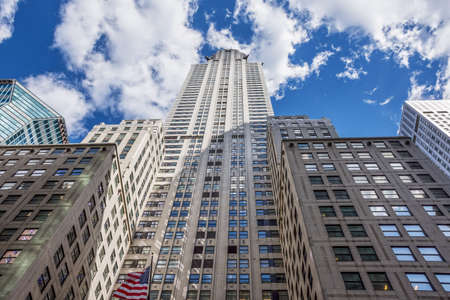 Towering classic New York City architecture against a blue cloud filled sky.のeditorial素材