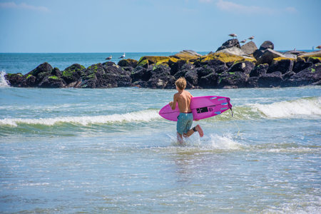 BELMAR, NEW JERSEY-AUGUST 1 - A boy runs into the surf on a beautiful Summer day on August 1 2015 in Belmar New Jersey.のeditorial素材