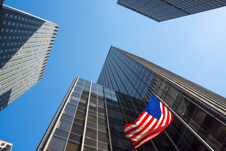 Skyscrapers and an American flag waving in mid-town Manhattan.の写真素材