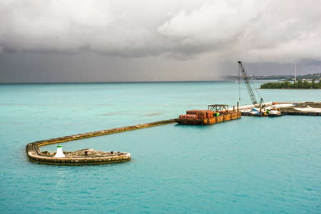 KINGS WHARF,BERMUDA, MAY 25 - Turquoise sea water and threatening skies over this pier in Kings Wharf on May 25 2016 in Bermuda.のeditorial素材