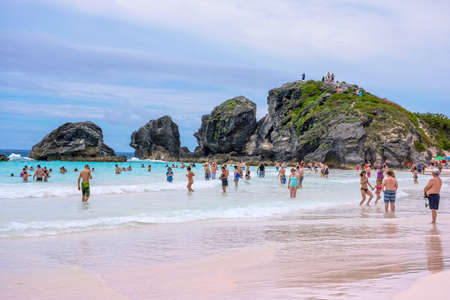 HORSESHOE BAY, BERMUDA - MAY 26 - Crowds of swimmers in the surf with large rock formations of Horseshoe Bay on May 26 2016 in Bermuda.のeditorial素材