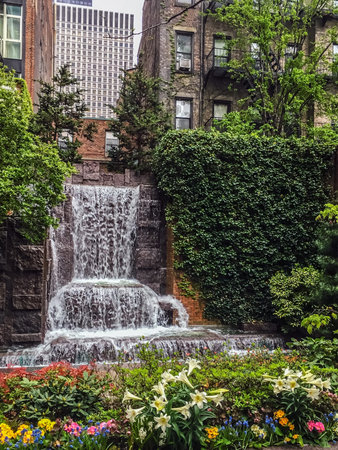 A waterfall among the apartment buildings in this small park on the East Side of Manhattan.の写真素材
