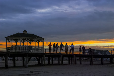 BELMAR, NEW JERSEY - SEPTEMBER 3 - A group of men converse at sunset on the old Belmar fishing pier destroyed during Hurricane Sandy on September 3 2010 in Belmar New Jerseyのeditorial素材