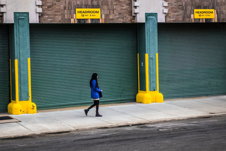 NEW YORK-MARCH 9: A girl with long black hair walks alone past a colorful garage in Tribeca on March...