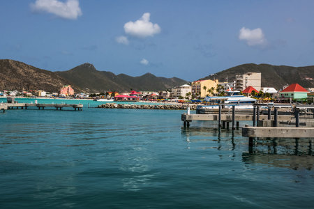 A scenic look at a marina with beach, hotels and mountains off in the distance.のeditorial素材