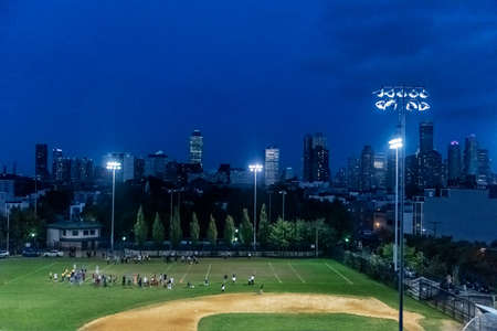 A night game in Jersey City New Jersey with the New York City skyline in the background.のeditorial素材