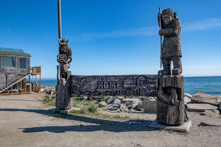 The wooden carved monument depicting a gold panner and native Alaskan on the shore of the Bering Sea in Nome Alaska.の写真素材
