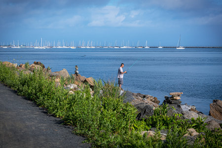 ATLANTIC HIGHLANDS, NEW JERSEY - JUNE 27: A man fishing on Sandy Hook Bay on June 27 2021 in...