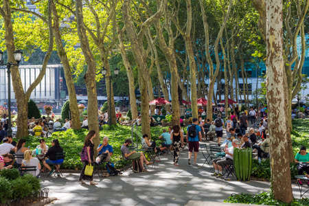 NEW YORK-JULY 22: A busy Summer day under the Sycamore trees in Bryant Park on July 22 2015 in Manhattan.のeditorial素材