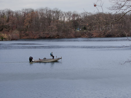 A man fishes on Lake Lefferts in Matawan NJ on an overcast Spring afternoon.の写真素材