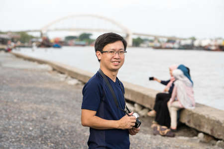 Kedah,Malaysia - 11-05-2019 : the asian chinese man with his camera in the seaside when in holiday.のeditorial素材