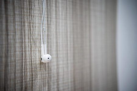 White earphone hanging on the wooden table