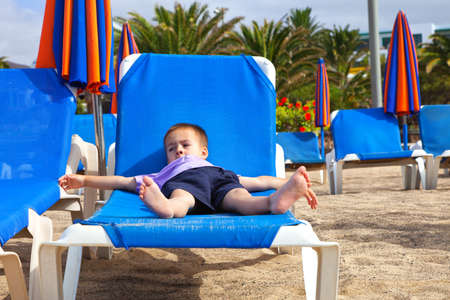 A child lying flat on a sunbedの写真素材