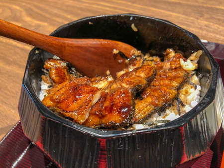 Unagi donburiâs a dish originating in Japan, a bowl filled with steamed white rice,topped with fillets of eel (unagi),glazed with a sweetened soy based sauce, called tare and caramelizedの写真素材