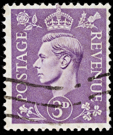 UNITED KINGDOM - 1937 - 1947: An English Three Pence Violet Used Postage Stamp showing Portrait of King George VI, 1937 - 1947 のeditorial素材