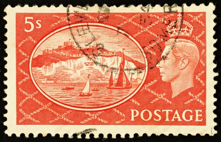UNITED KINGDOM - CIRCA 1951: An English Five Shilling Red Used Postage Stamp showing Portrait of King George VI and the White Cliffs of Dover, circa 1951 のeditorial素材