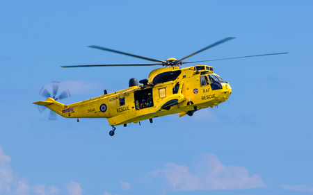 DAWLISH, UNITED KINGDOM - AUGUST 23, 2014: Royal Navy Sea King Search and Rescue Helicopter Flying at the Dawlish Airshowのeditorial素材