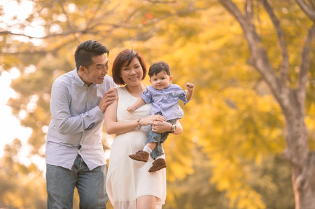 Asian young family having fun outdoors in autumnの写真素材