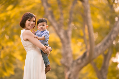 Asian mother and son having fun outdoors の写真素材