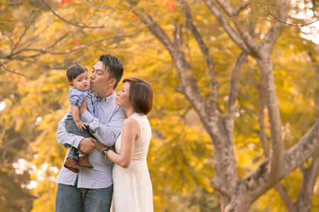 Asian young family having fun outdoors in autumnの写真素材