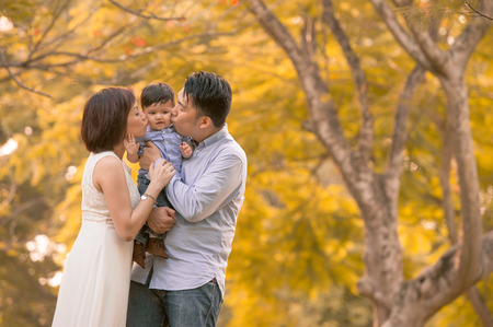 Asian young family having fun outdoors in autumnの写真素材