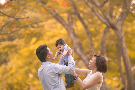 Asian young family having fun outdoors in autumnの写真素材