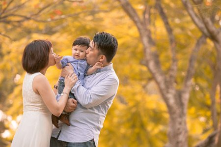 Asian young family having fun outdoors in autumnの写真素材