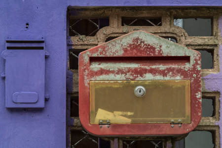 Old red mailbox on purple wall