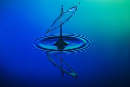 water drop collision on a blue backgroundの写真素材