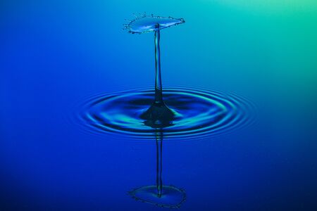 water drop collision on a blue backgroundの写真素材