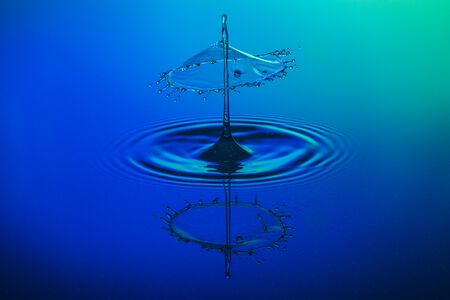 water drop collision on a blue backgroundの写真素材